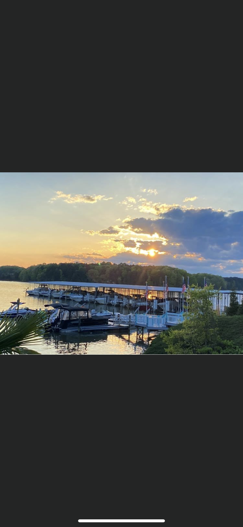 Lake Norman marina at golden hour with American flags and forested shoreline