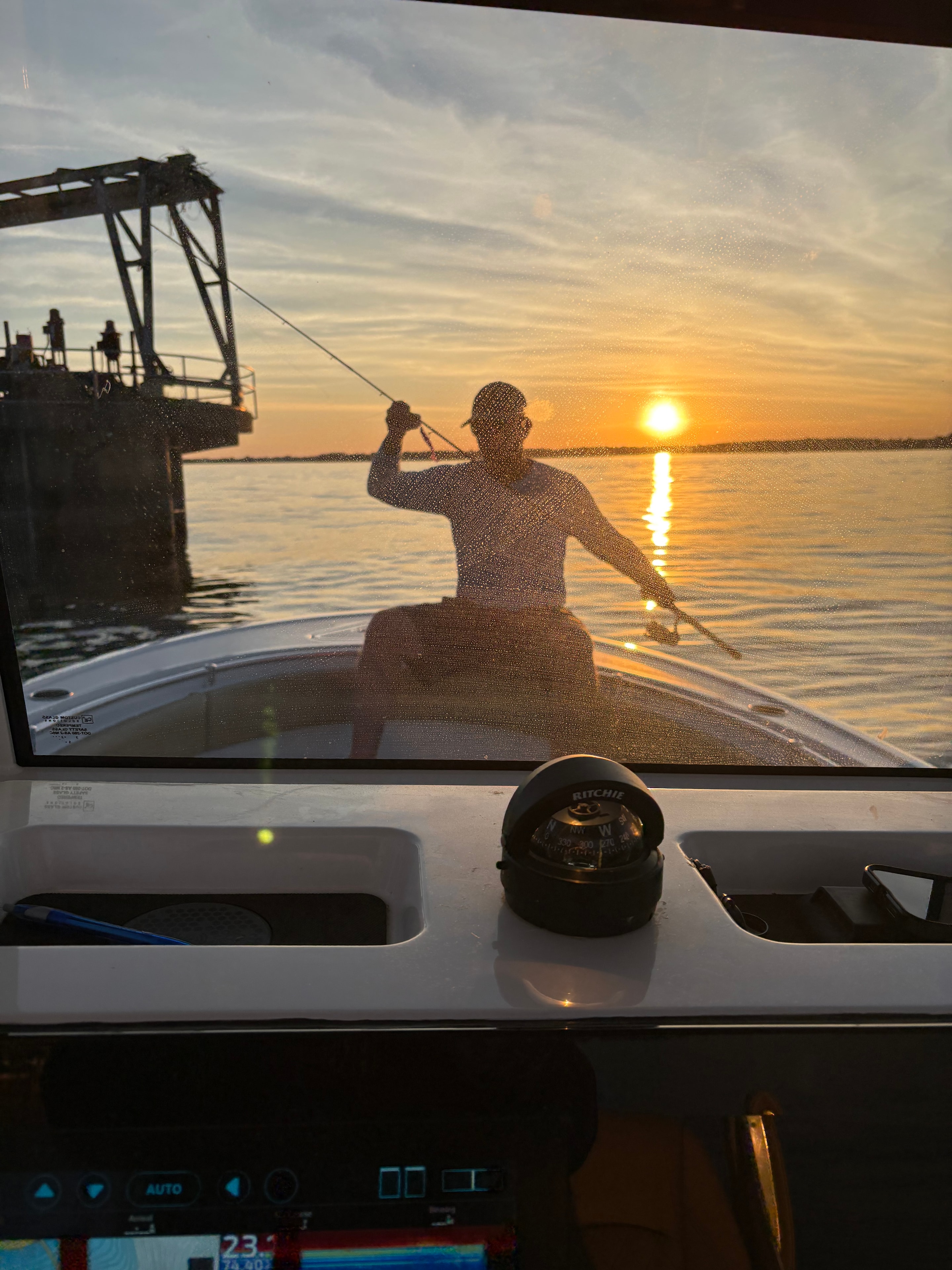 Wakeboarder silhouetted against a golden Lake Norman sunset